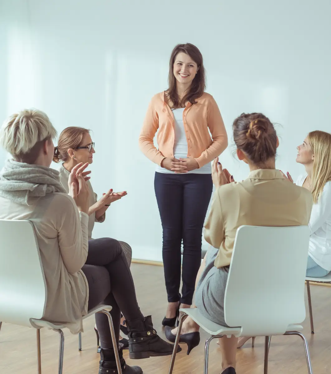 Woman standing in front of a group of women sitting in chairs